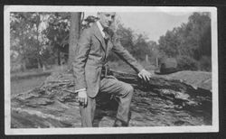 Hoagy Carmichael posing beside a large rock.