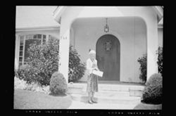Lida Carmichael on front walk of a house.
