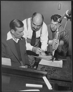 Hoagy Carmichael at the piano in a CBS radio studio with two unidentified men.