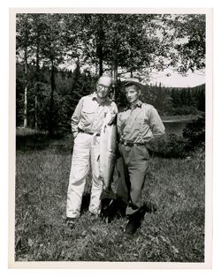 Two men posing with fish