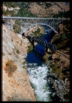 US Alt 40 crosses WPRR and Feather River on steel arch bridge near Pulga, Butte county, California.