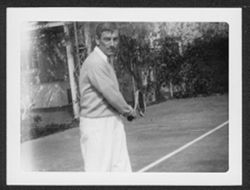 Hoagy Carmichael with tennis racket on court.