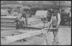 Picture postcard of Munson Robison (left) working in a lumber yard.