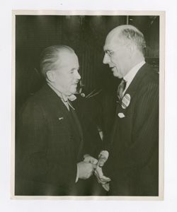 Roy Howard shaking hands with another man