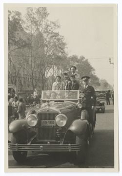 Item 0468. Scenes from parade for athletic-military maneuvers, 20 Nov. 1931. Taken from in front of car . Eisenstein in front passenger seat - in back - standing, two unidentified men and Tissé (with camera) standing on running board, a policeman.