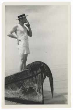 Item 0545. Various shots of Kimbrough and others in and around sailboats and canoes. Location probably the same as for items 536-540 above. Kimbrough standing in bow of boat, smoking a cigarette, with alligator draped over bow at his feet.