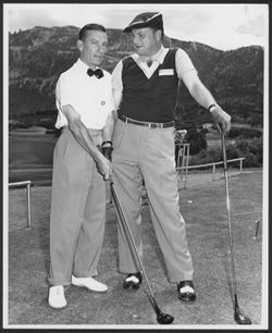Hoagy Carmichael posing with an unidentified man on a golf course, early 1950-1951.