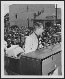Hoagy Carmichael on stage in La Grange, Georgia, playing piano, crowd in background.