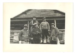 Roy Howard and companions in front of log cabin
