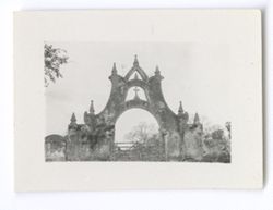 Item 0958. - 0958a. Stone archway with cross in middle-level opening and a wooden gate in the center.