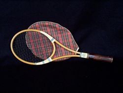 Tennis racket with red plaid racket holder.
