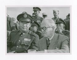 Roy Howard contemplating with military personnel