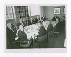 Roy and Jack Howard with others at a dining table