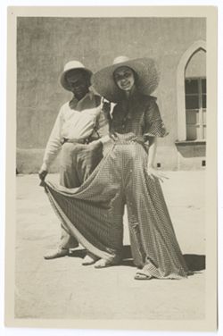 Item 0393a. Various shots of Eisenstein and a young woman wearing a checked culotte with wide leg in the courtyard of the Hacienda. Standing side by side