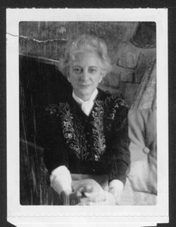 Georgia (Carmichael) Maxwell seated in front of a fireplace.