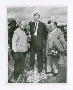 Roy Howard and company standing outside of a plane