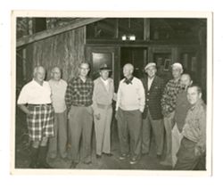 Group of men standing in front of a cabin at Bohemian Grove