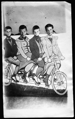 Carmichael family: Randy, Hoagy, Hoagy Bix and Ruth, behind a carnival cutout of people on a bicycle built for four.