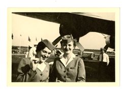 Flight attendants smile by plane