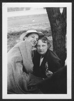Martha Carmichael and unidentified friend seated under a tree.