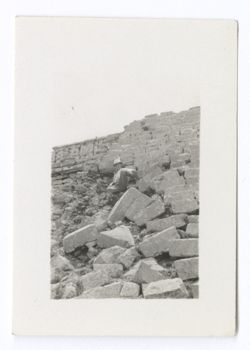 Item 1060. Man seated on the stairway of the Nunnery. A portion of the building itself is visible in upper left background.