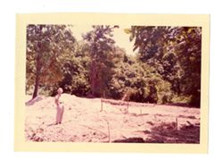 Woman standing in front of a wooded area