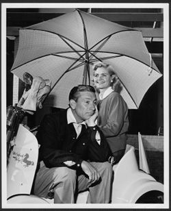 Hoagy Carmichael posing on a golf cart with an unidentified woman.