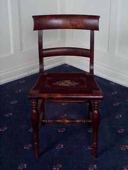 Straight-back chair with flower needlepoint design.