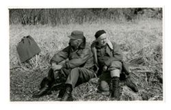 Two men sitting in a field