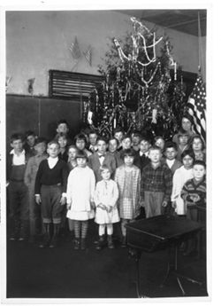 Group of school children in front of Christmas tree
