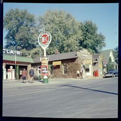 Sinclair Gasoline sign, outside Nashville Realty Co., along road with people, view from opposite direction and on the far side of the street
