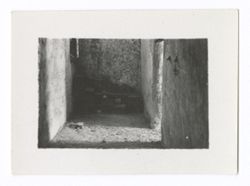 Item 0972. Interior of narrow hall with sunlight coming from opening in right-hand wall.