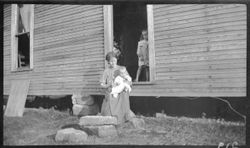 Near Foster cabin--lady with babe, in doorway