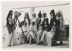 Item 0330. Eleven young Mexican women wearing mantillas and carrying fans. One stands at left behind camera on tripod. Others are seated or standing in two rows in front of camera. Taken on upper level of bullring, Mérida.