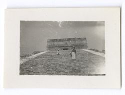 Item 0999. A man (possibly Alexandrov) standing half-way up the steps of the Castillo. Another man (possibly Eisenstein) seated further up the steps. Long shot from base of Castillo.