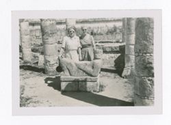 Two women posing with a Maya chacmool