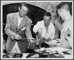 Randolph Scott (left) serving food to and with unidentified people.