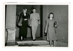 Man and two women leaving building
