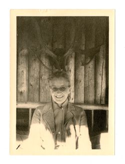 Woman standing in front of deer antlers on wall
