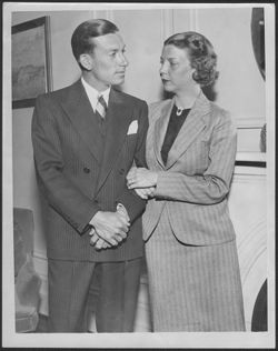 Hoagy Carmichael and Ruth Carmichael posing in front of a fireplace.