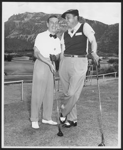 Hoagy Carmichael posing with an unidentified man on a golf course, early 1950-1951.