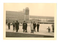 People standing on tarmac outside of a building