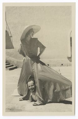 Item 0394b. Various shots of Eisenstein and a young woman wearing a checked culotte with wide leg in the courtyard of the Hacienda. Eisenstein is lying on the ground, looking out from between the spread legs of the girl's culotte.