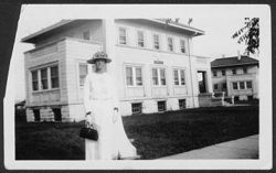 Lou Manley in white dress before building marked Wisconsin Hall, ca. 1920.