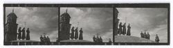 Item 0247. Long shots of three monks standing on a hill, the one in the center holding a cross. Behind them is a church tower. Approaching at right, another group of three monks, the one in the center carrying a cross, and to their left a single monk.