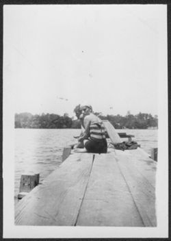 Martha Carmichael and Russ Knecht seated on a dock at Lake Wawasee, Indiana.