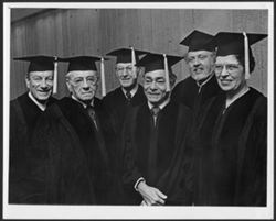 Hoagy Carmichael in academic robes standing with unidentified people, Indiana University.