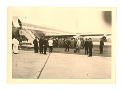 Passengers standing outside of an airplane