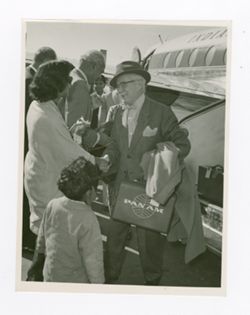 Roy Howard greeting woman outside of plane