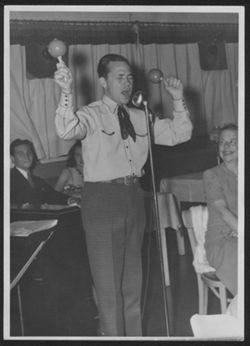Johnny Mercer playing maracas and singing.